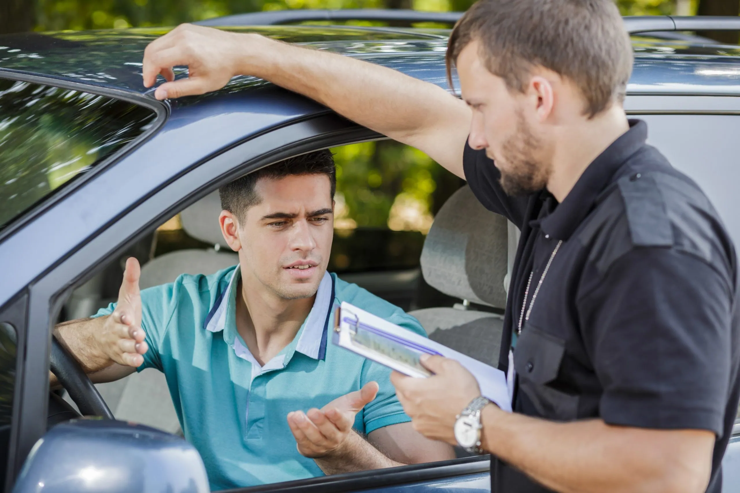 Police officer explaining the driver over his license penalties.