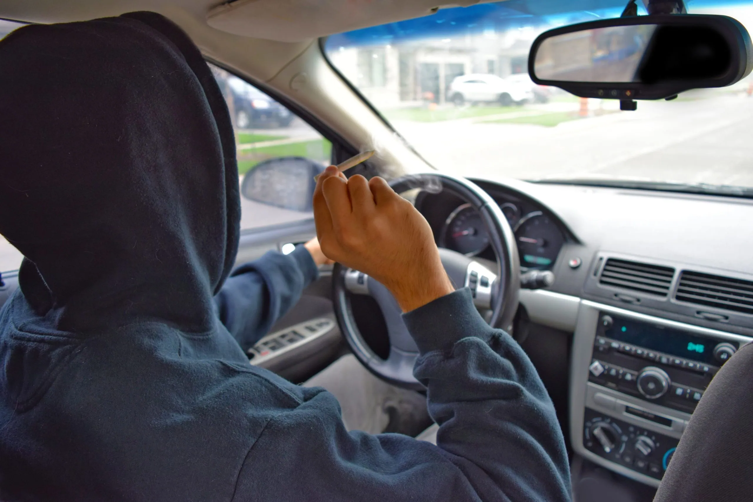Man driving while smoking marijuana.